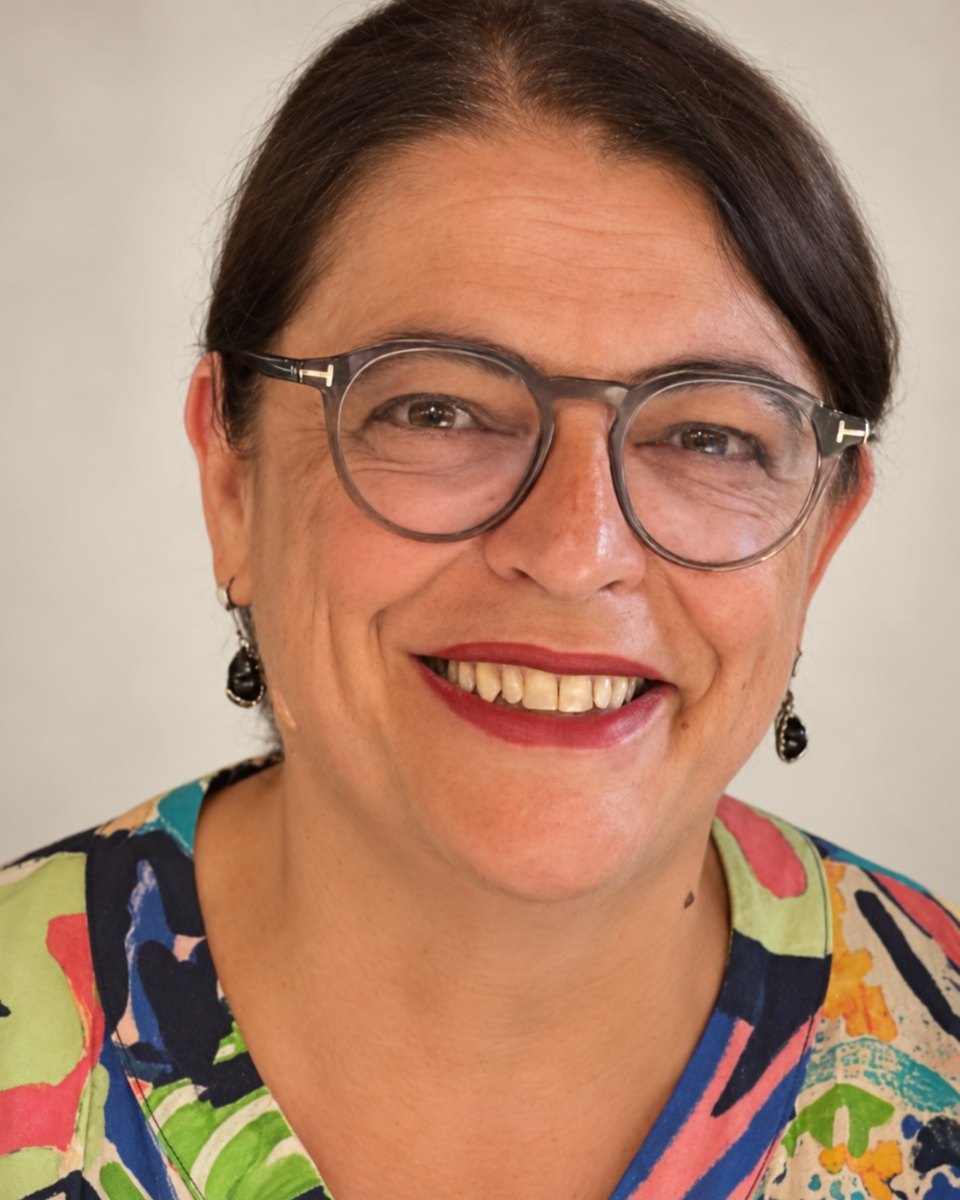 Isabel Serra, thérapeute en chromatothérapie à Auderghem, souriante, en chemisier coloré